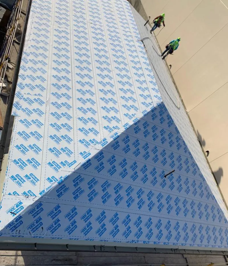 Professional roofers installing underlayment on a metal roof in Miami